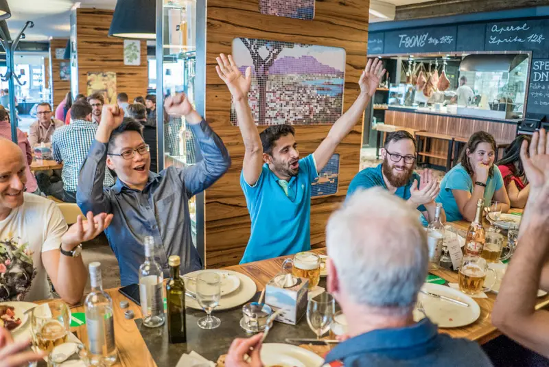 Winnaars vieren feest bij Treasure Hunt Antwerp — team juicht in een restaurant