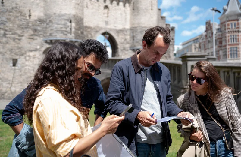 Tony's Chocolonely-teamleden overleggen over een Treasure Hunt-puzzel in Antwerpen